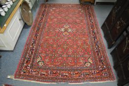 A Persian rug, red ground with all over stylised decoration 210cm x 145cm.