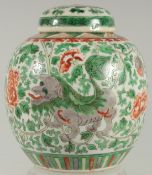 A CHINESE FAMILLE VERTE PORCELAIN JAR AND COVER, painted with foo dogs and large flower heads
