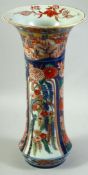 A LARGE JAPANESE IMARI PORCELAIN SLEEVE VASE, painted with a village landscape with panels of