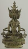 A FIGURE OF A SEATED MULTI-HEADED DEITY, 22cm high.
