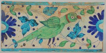 A LARGE EARLY 19TH CENTURY MUGHAL NORTH INDIAN MULTAN PARROT POTTERY TILE, 31cm x 15cm.