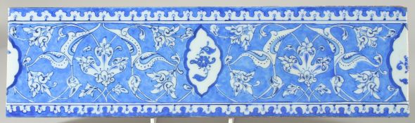 AN OTTOMAN TURKISH GLAZED POTTERY TILE, Baba Nakkas design, 39.5cm x 11cm.