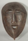 A LARGE AFRICAN TRIBAL CARVED WOOD MASK, 38cm x 25cm.