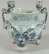 A CHINESE BLUE AND WHITE PORCELAIN TRIPOD CENSER, with moulded dog handles, 20.5cm high.