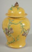 A CHINESE QING DYNASTY YELLOW GROUND SANCAI GINGER JAR AND COVER, relief decorated with blossoming