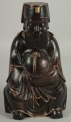 A FINE CHINESE CARVED HARDWOOD FIGURE OF A SEATED IMMORTAL, with painted gilt highlights, the