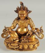 A TIBETAN GILT ALLOY FIGURE OF A SEATED DEITY, 15cm high.