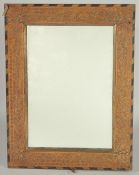 AN ISLAMIC BRASS INLAID WOODEN MIRROR, 42cm x 32cm.