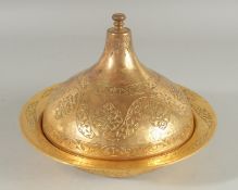 AN OTTOMAN TURKISH GILDED COPPER LIDDED DISH, with engraved foliate motifs, 23cm diameter.