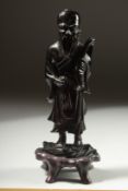 A CHINESE BAKELITE FIGURE on a fitted wooden stand, figure 15cm high.