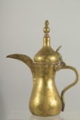 A STAMPED ISLAMIC BRASS COFFEE POT, 27cm high.