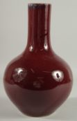A LARGE CHINESE OX BLOOD GLAZE PORCELAIN VASE, the base with six-character mark, 33.5cm high.