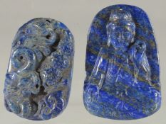 TWO CARVED LAPIS LAZULI PENDANTS.