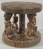 A SMALL AFRICAN DOGON TRIBE CARVED WOODEN STOOL, 18cm high.