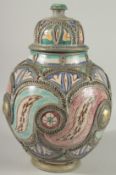 A MOROCCAN METAL MOUNTED POTTERY LIDDED JAR, the jar painted with foliate motifs, 37cm high.