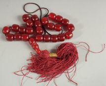 A STRING OF PRAYER BEADS AND TOGGLE -possibly bakelite.