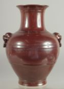 A CHINESE MOTTLED RED GLAZE TWIN HANDLE VASE, with impressed mark to base, 25cm high.