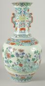 A CHINESE DOUCAI PORCELAIN TWIN HANDLE VASE, painted with birds and native flora, six-character mark