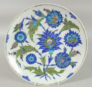 AN OTTOMAN TURKISH GLAZED POTTERY PLATE, painted with flora, 30.5cm diameter.