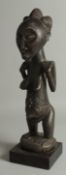 AN AFRICAN CARVED WOOD LUBA-HEMBA ANCESTOR FIGURE, mounted to a wooden base, 44cm high overall.