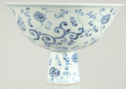 A CHINESE BLUE AND WHITE PORCELAIN STEM BOWL, decorated with phoenix and flora, 17cm diameter.