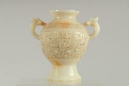 A CHINESE CARVED WHITE JADE TWO HANDLED VASE. 7ins high.