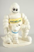 A CAST IRON MITCHELIN MAN and dog. 8ins high.