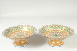 A SUPERB PAIR OF RUSSIAN PORCELAIN CIRCULAR COMPORTS. 8.75ins diameter, 3.5ins high. The centre with