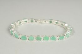 A SILVER EMERALD SET LINE BRACELET.