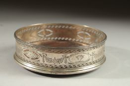 A GEORGE III SILVER CIRCULAR WINE COASTER with pierced sides and engraved with floral garlands. 5.