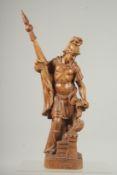 A GOOD 19TH CNTURY CARVED WOOD ROMAN SOLDIER holding a coloured flag and standing beside a fire.
