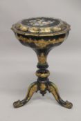 A VICTORIAN PAPIER MACHE TEA POUY ON A TRIPOD BASE, inlaid with mother of pearl and decorated in