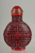 A CARVED CINNABAR SNUFF BOTTLE AND STOPPER. 3.5ins high.