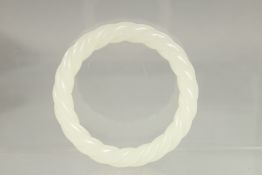 A WHITE JADE TWIST BANGLE. 3ins diameter.