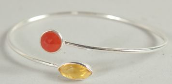 A SILVER BANGLE set with two stones.