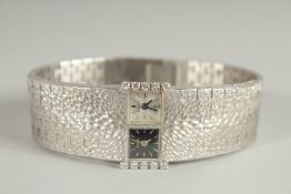 A LADIES PIAGET 18CT WHITE GOLD DOUBLE DIAL WRIST WATCH with black and plain dial. NO. 148269 & 1038