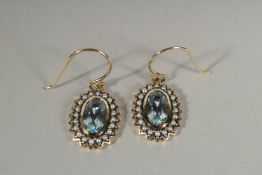 A PAIR OF 9CT GOLD BLUE TOPAZ AND SILVER PEARL DROP EARRINGS.