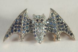 A SMALL MULTI GEM STONE BAT BROOCH.