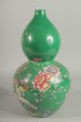 A CHINESE GREEN PORCELAIN DOUBLE GOURD VASE decorated with flowers. Six-character mark in blue.