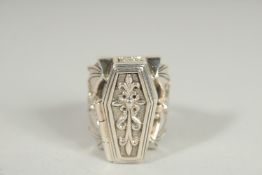 A SILVER COFFIN AND SKELETON BATS WING RING.