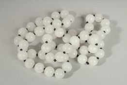 A STRING OF WHITE BEADS. 30ins long.