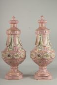 A GOOD PAIR OF SEVRES DESIGN PINK PORCELAIN VASES AND COVERS with garlands and panels of flowers.