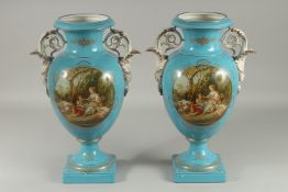 A LARGE PAIR OF SEVRES DESIGN TWO HANDLED URN SHAPED VASES with reverse oval of classical figures.