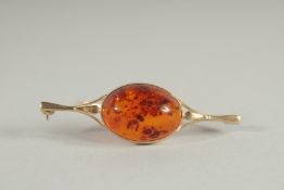 A 9CT GOLD AND AMBER STICK PIN.