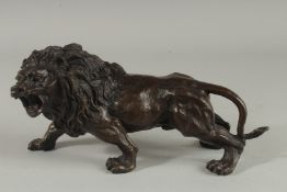 A BRONZE LION. 11ins long.