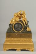 A GOOD EMPIRE ORMOLU AND BRONZE CLOCK the case with two gilded figures. 13ins high.