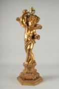 A CARVED GILDED CHERUB LAMP. 23ins high.