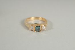 A 14K GOLD BLUE DIAMOND AND DIAMOND THREE STONE, PRINCESS CUT RING.