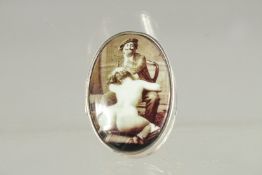 A STERLING SILVER OVAL PILL BOX the lid with a nude. 1.25ins x 1in.