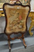 A VICTORIAN ROSEWOOD FRAMED FIRE SCREEN with needlework panel. 3ft 8ins high.